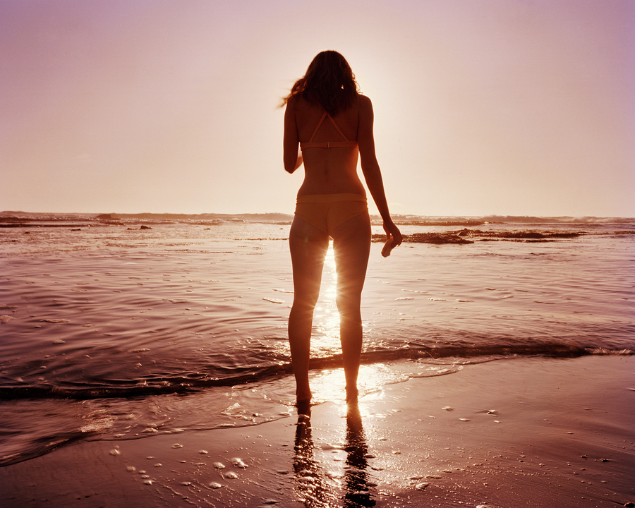 Стройная нудистка гуляет по пляжу вечером и валяется на песке