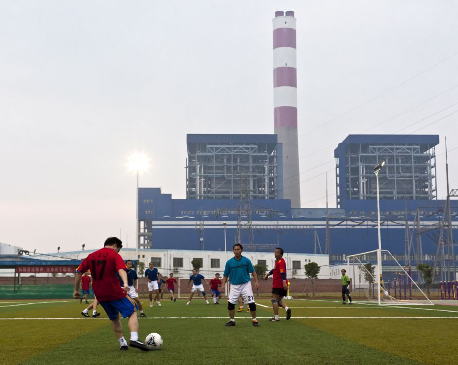 Fangchenggang, Nov. 21, 2010: A football match between power station employees and a local shipping firm is played in the shadow of a super-critical coal power station. (Photo by Toby Smith. Reportage by Getty Images.)